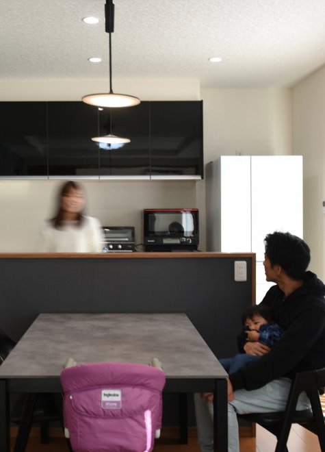 『採光性に優れた、自然と家族が集うリビング空間』のあるクールで黒い外観の家。