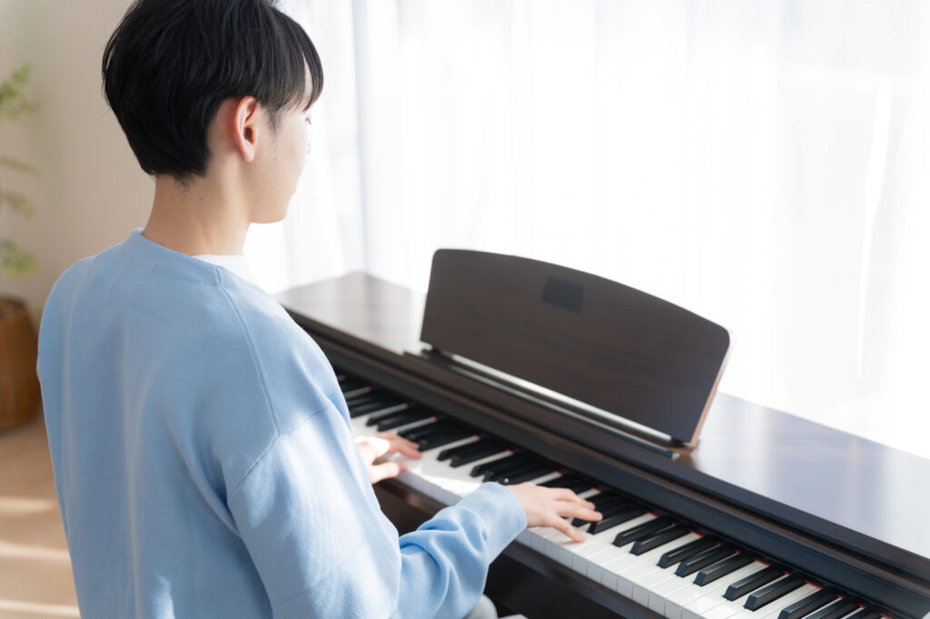 自宅の防音室でピアノを弾く男性